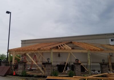 Construction site at a commercial building showing an unfinished wooden structure under a cloudy sky.