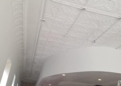 White embossed ceiling with detailed texture and multiple hanging light fixtures in a modern interior space.